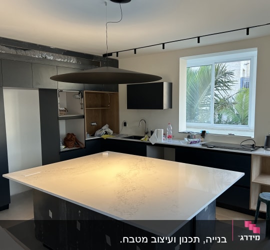 מטבח מודרני עם אי גדול, כיור וברז, קומקום חשמלי, חלון גדול